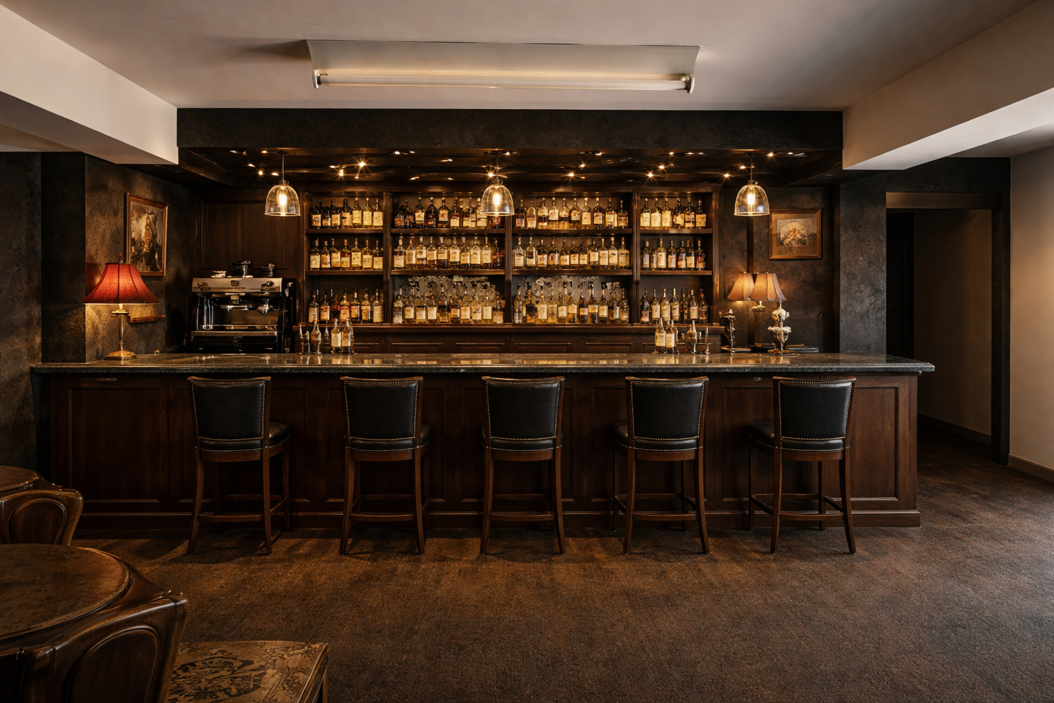 Bar area with whisky selection and leather bar stools in the Red Bowler Lounge